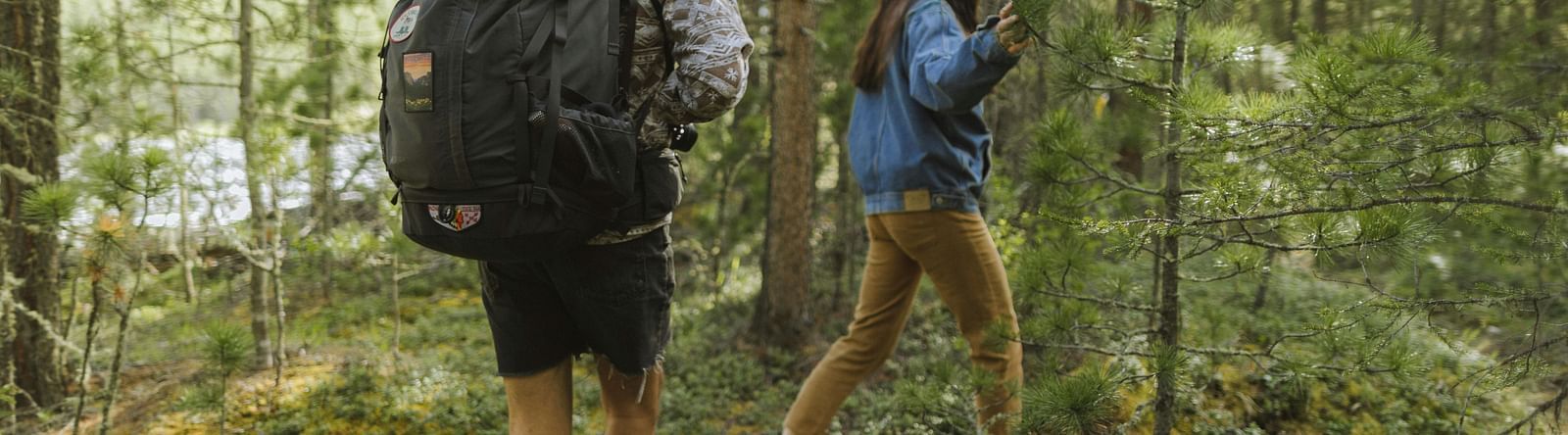 Two people trekking in a forest
