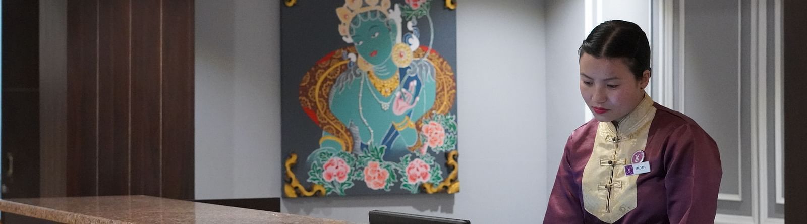a woman welcoming at the reception desk at Sumitel Pelling, Geyzing