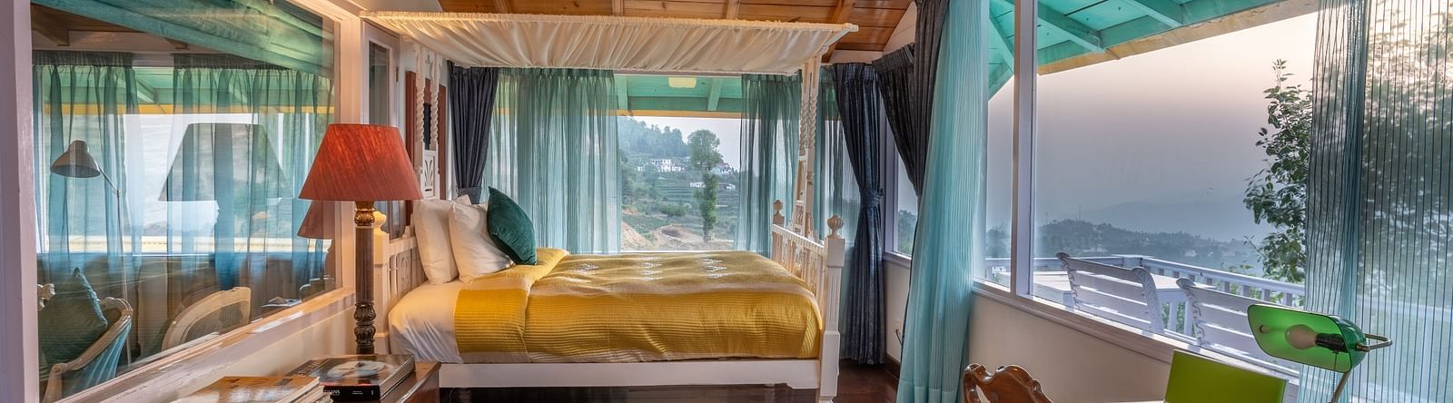 wide angle view of a room with a bed and large windows at Te Aroha By Shervani, Mukteshwar