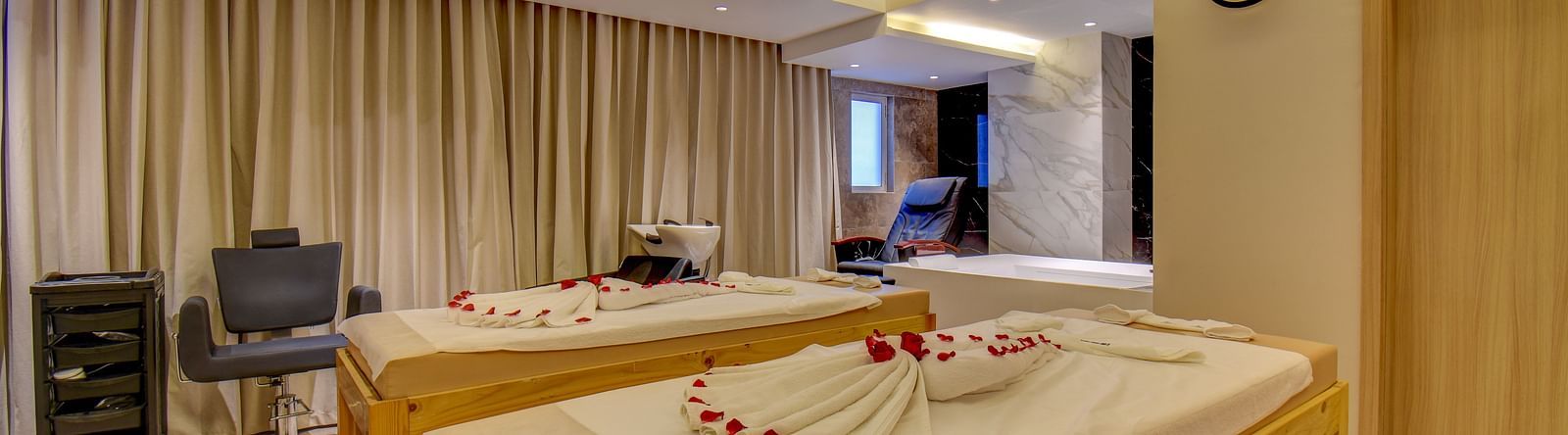 Overview of two Spa bed at The SSK Solitaire Boutique Hotel & Spa, Gangapur Road - Nashik featuring a towel in heart shape and flower petals.