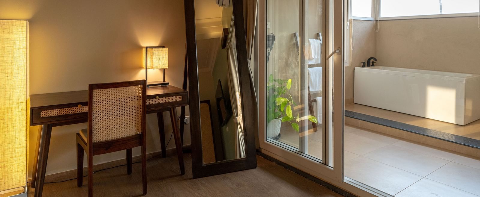 Well-lit room with work desk, mirror, and a view leading to the outdoor bathtub at Kssemya.