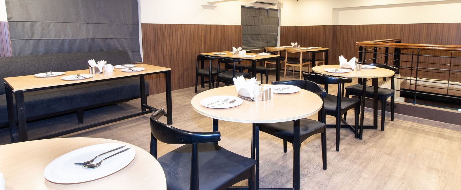 A dining area set up with tables and chair in a warm lit ambience - Sanctum Suites Richmond Road, Bangalore