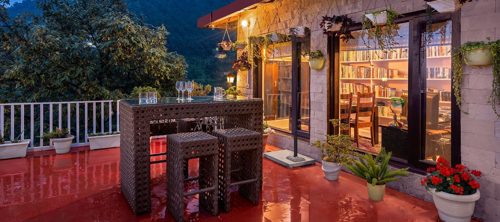 Cosy outdoor patio and a library, set against a mountain backdrop at dusk, at BluSalzz Collection - Suvaasa Resort, Ramgarh.