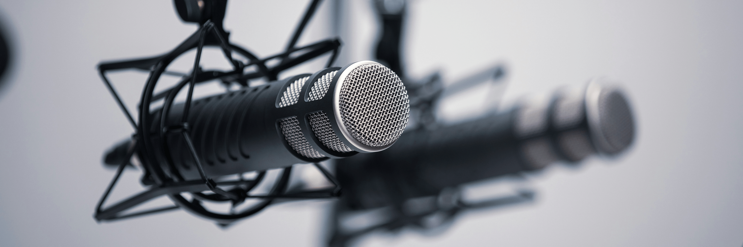 A podcast setup featuring a professional studio microphone mounted in a shock mount on an adjustable boom arm.
