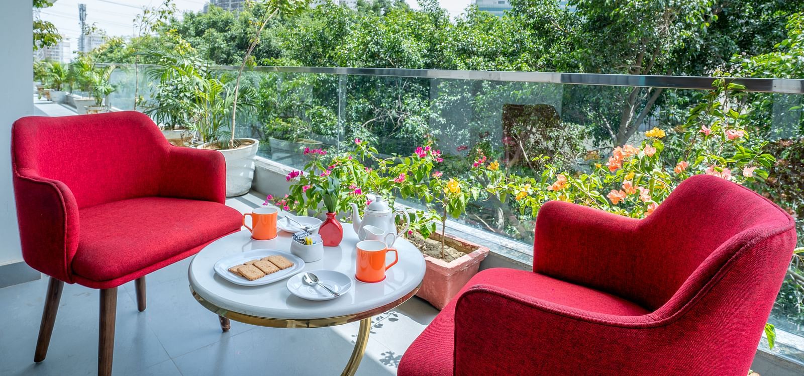 An image of a sitting area at the balcony with one centre table and two chairs | Inde Hotel Golf Course Extension