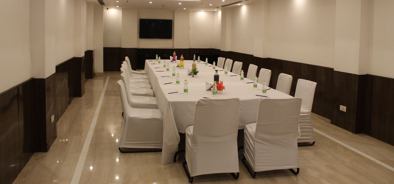An image of a conference room at Inde Hotels Vista Woods featuring a huge table surrounded by several chairs
