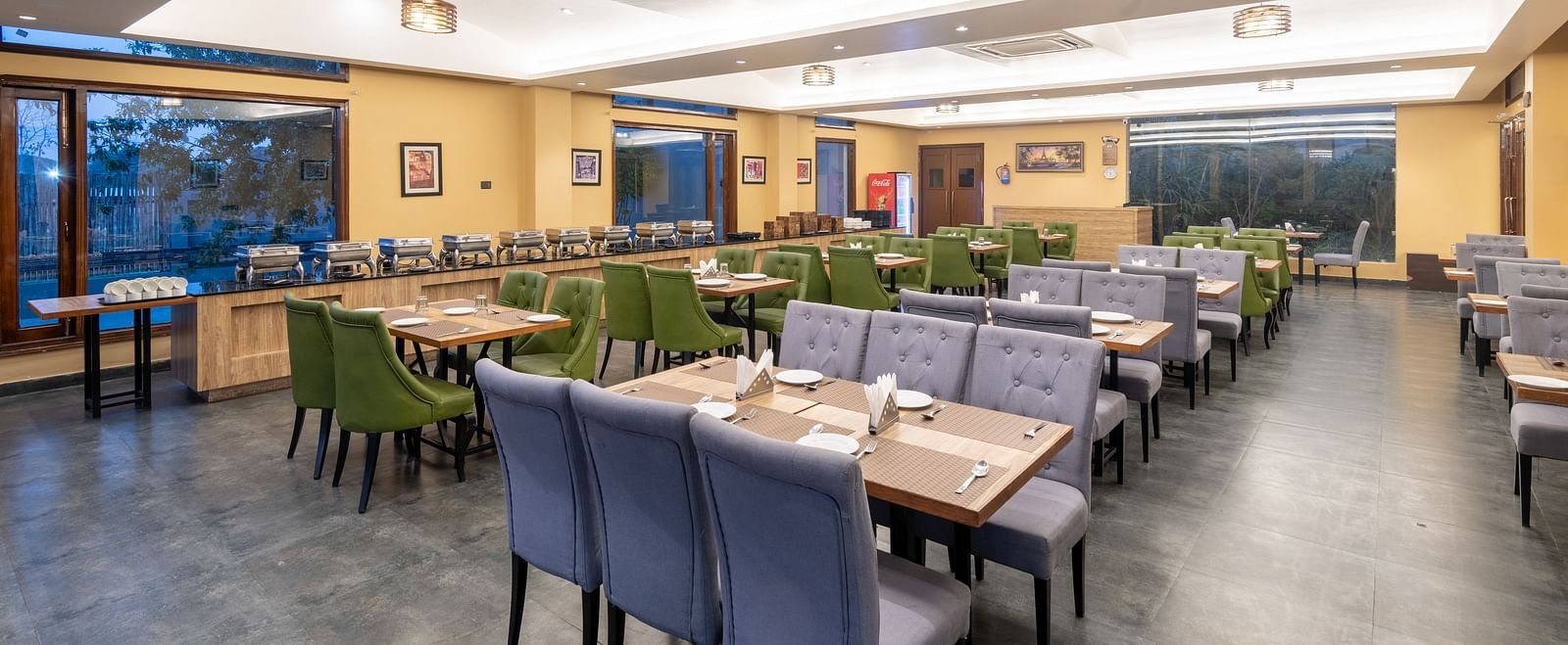 Diagonal view of the restaurant at DLS Forest Vines Resort, featuring tables and seating set for guests.