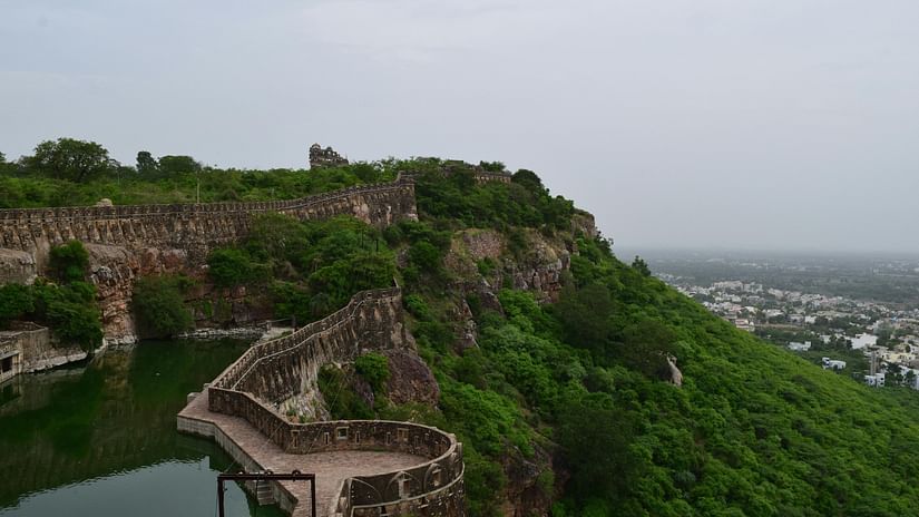 A view of a fort with a water body in its premises overlooking a city