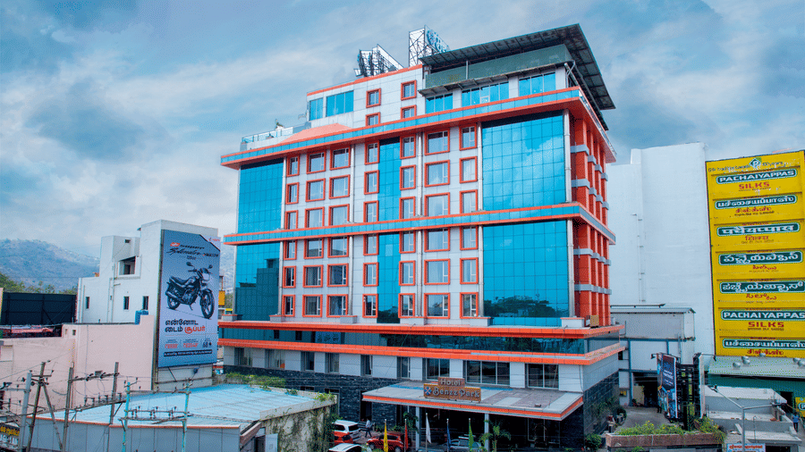 Facade shot of Benzz Park, Vellore, featuring the entrance on the bottom of the building along with a cloudy sky in the background.