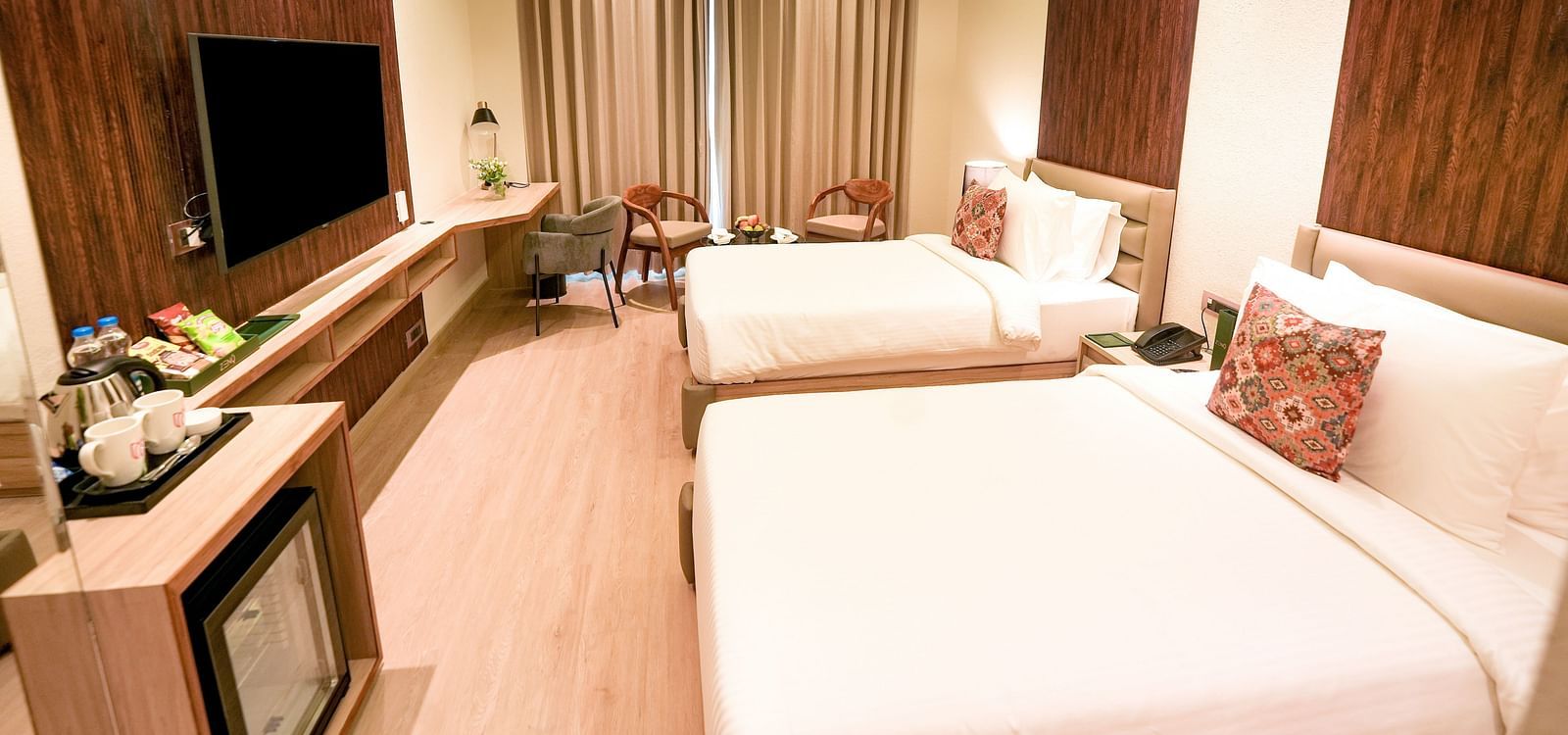 An image of a room in Bankhandi with twin beds, a minibar, a wall-mounted television and chairs - NAMAMI BY ZENQ BANKHANDI