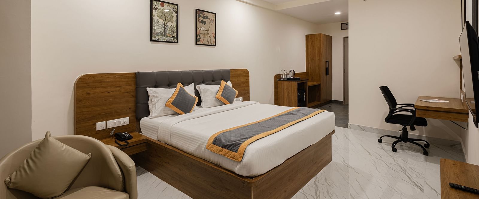 Well-furnished guest room with desk, chair, and king-size bed at Lemonridge Hotels, IDPL Balanagar.