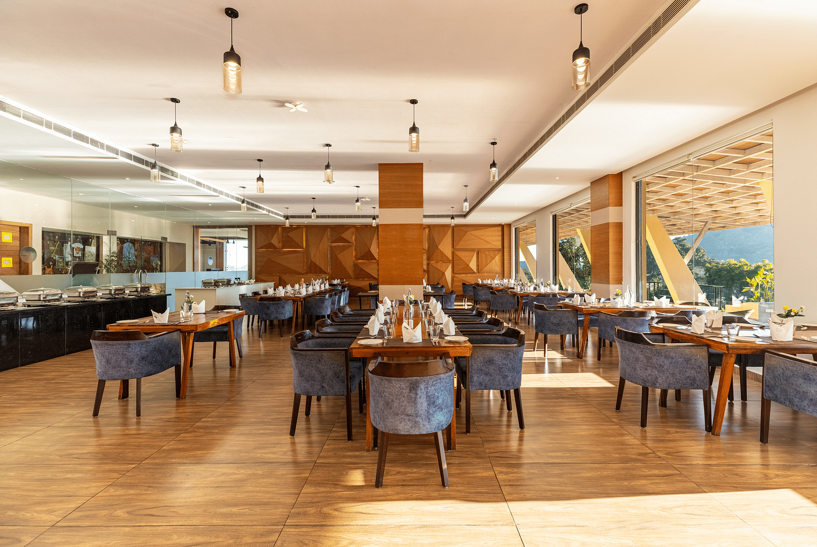 Restaurant interior with tables, chairs, and large windows under a warm lighting - 