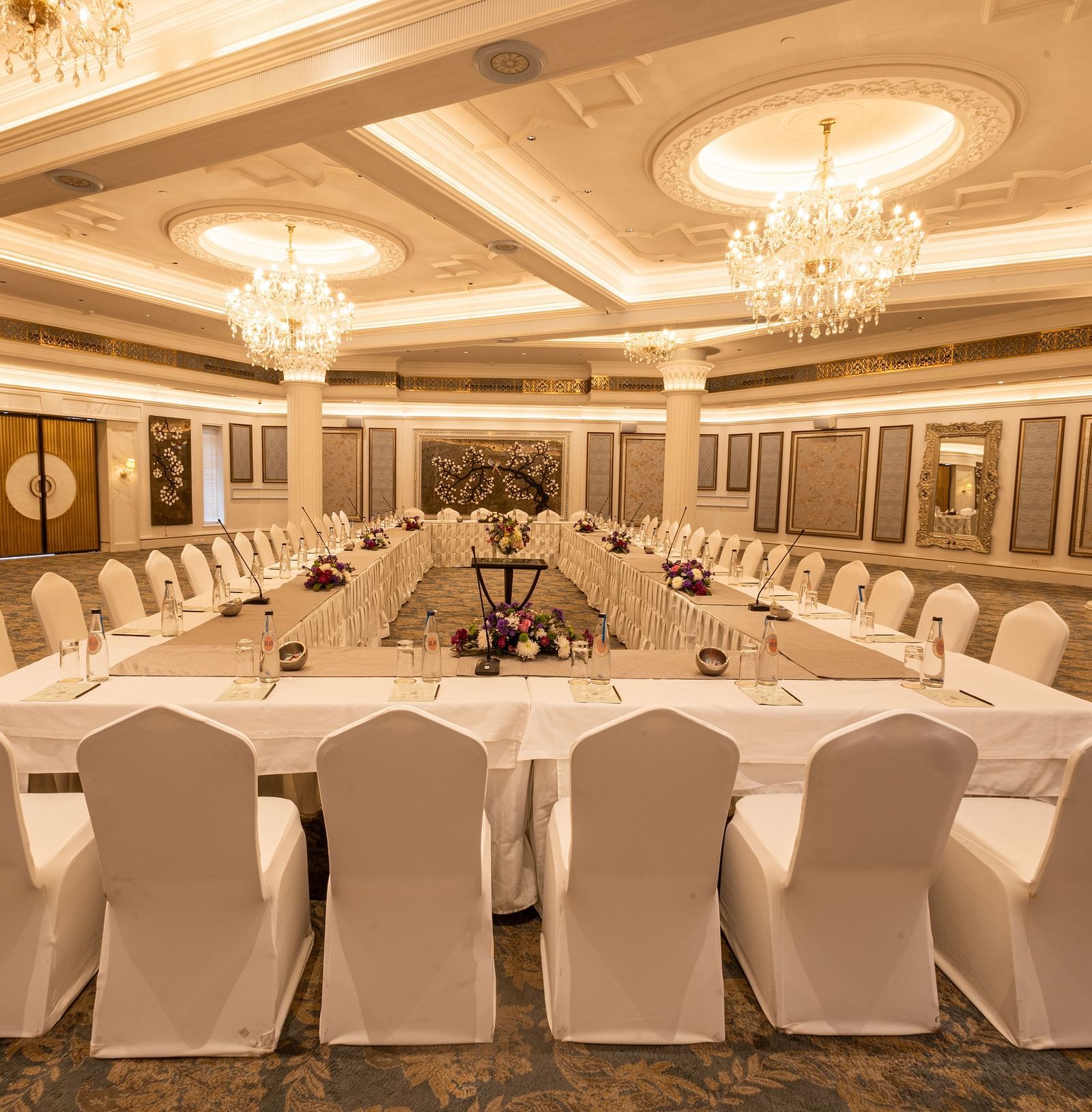 Image featuring the Viceroy Hall event venue at The Claridges New Delhi, showcasing seating arrangements and an elegant chandelier hanging overhead