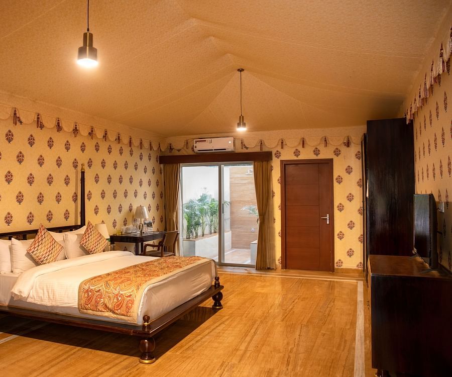 The interiors of our tent suites in Pushkar with a bed, a sofa set and tasteful decor 
