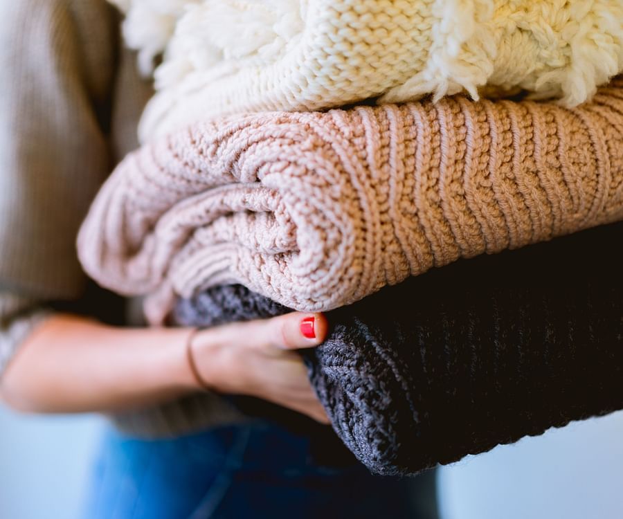 A person holding folded laundry