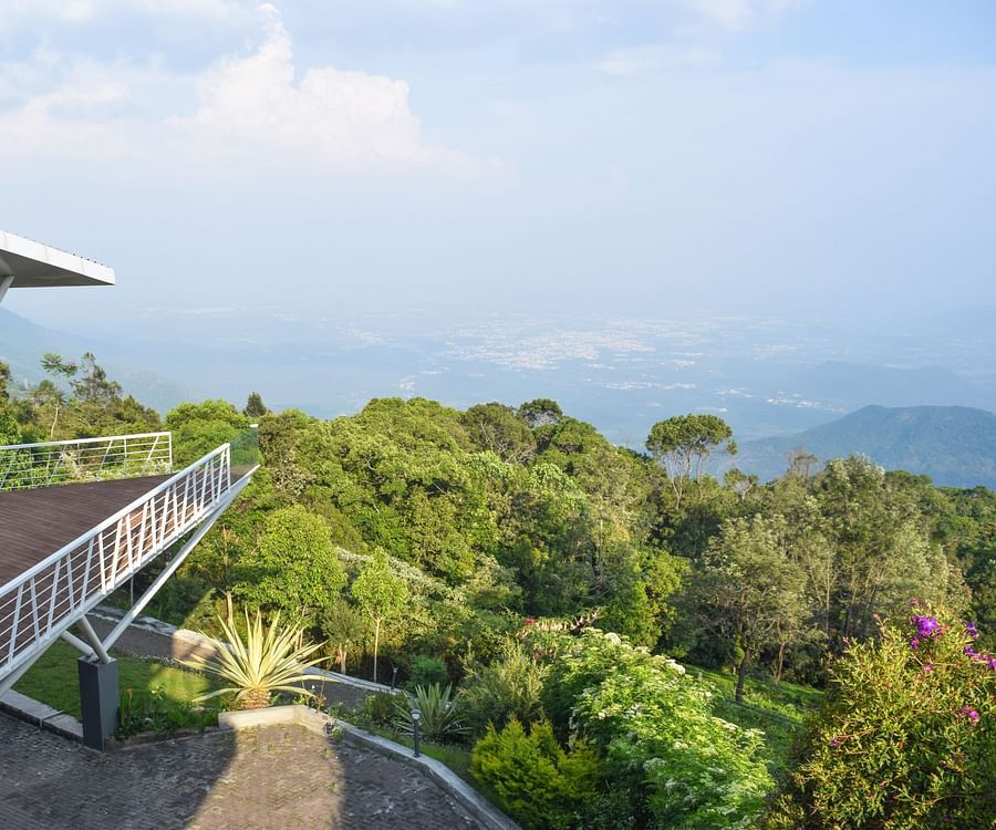 Spacious balcony offering a view of a bright, cloudy sky and distant horizon at Ibex Resorts, Coonoor (Tapas).