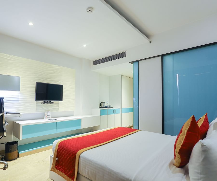 Side view of the studio room with a cozy king bed and a working table with a chair in the corner at Icon Premier Hotel by Bhagini, Devarabisanahalli