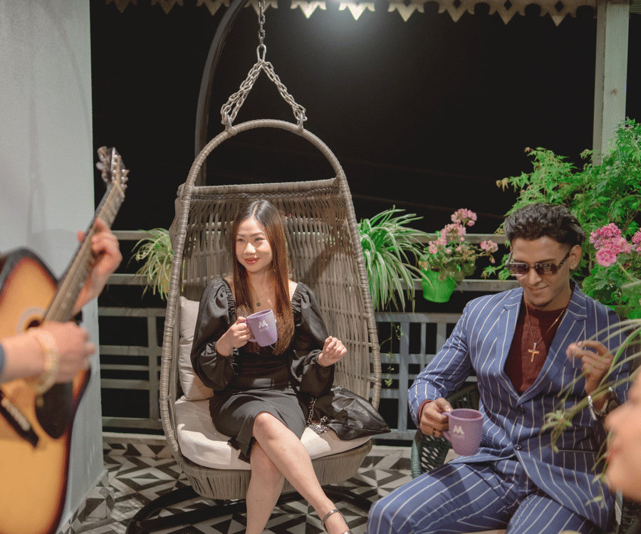 Guests enjoying live Karaoke in a lounge, sipping beverages while a guitarist performs in a relaxed evening setting.