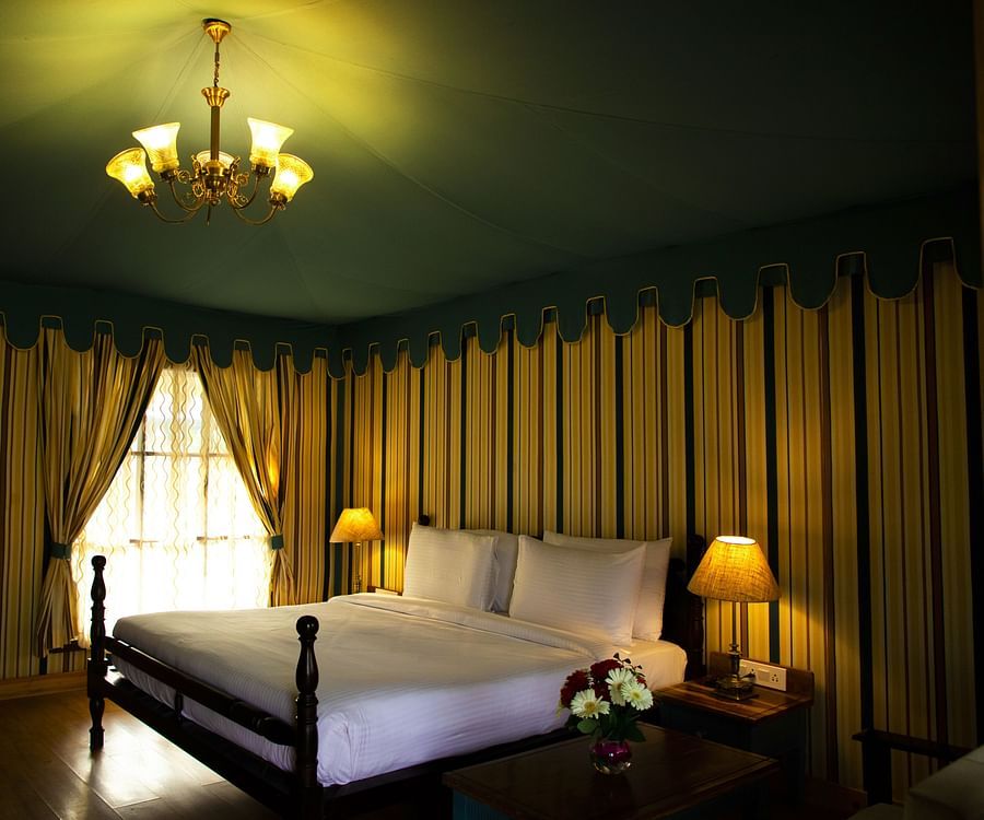 A white bed surrounded by walls with patterns of vertical lines