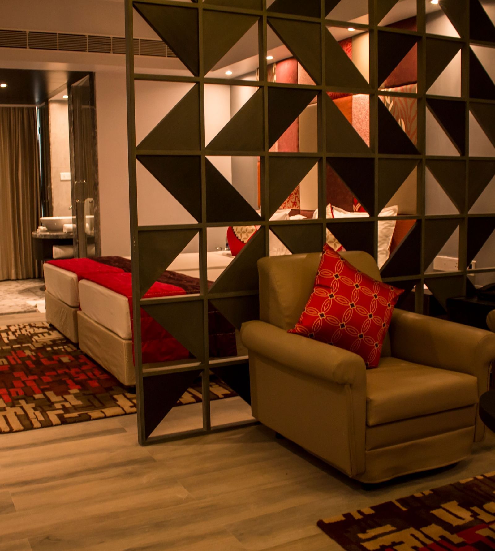 Full view image of sofa and table kept inside a hotel room Image of a room with a bed and  pillows arranged on it  along with  a balcony | Regency Tirunelveli By GRT Hotels