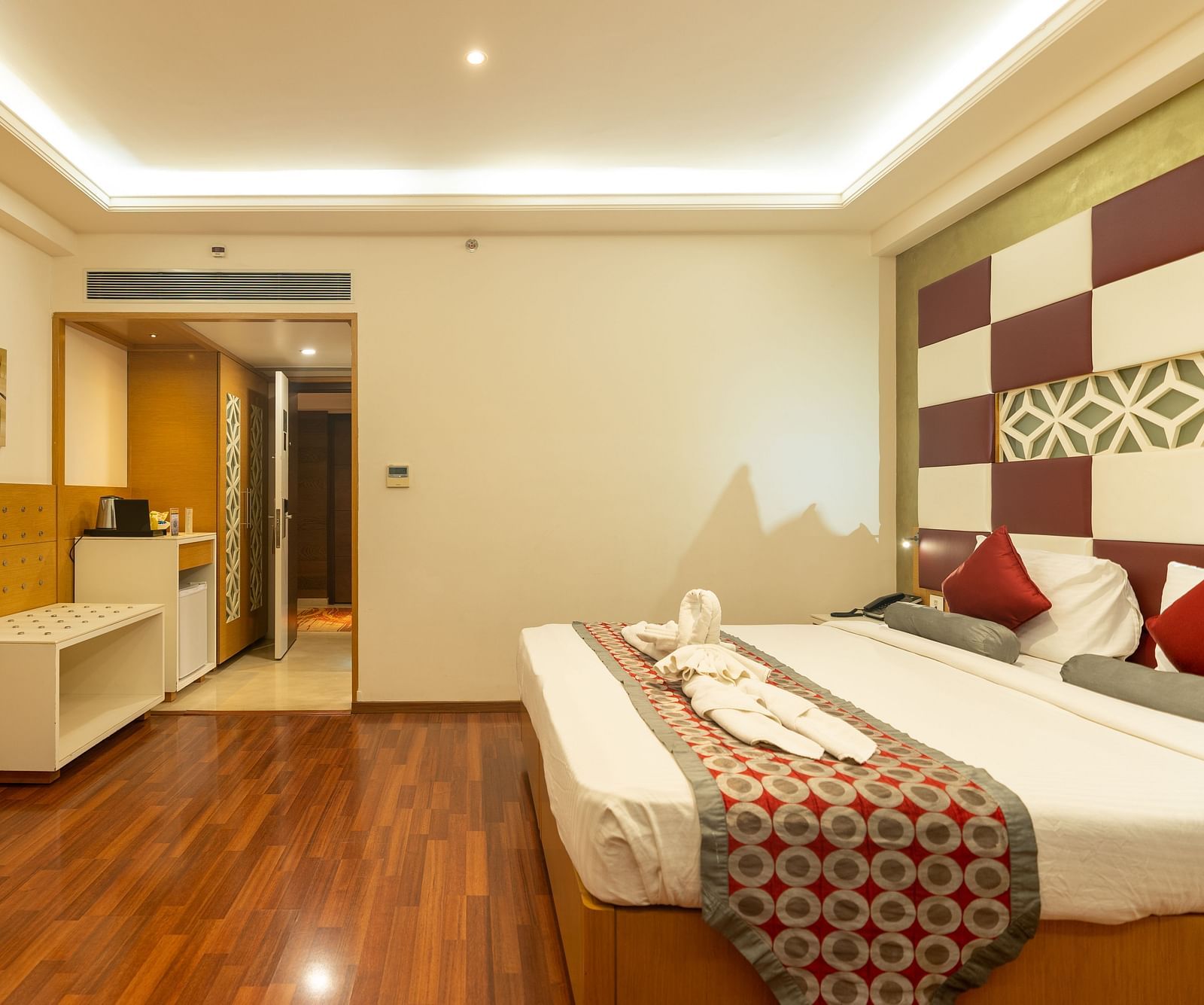 Bedroom with king size bed and tv at The President Hotel, Hubli