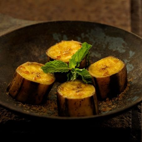 Cooked plantain slices with mint and spices in a pan.