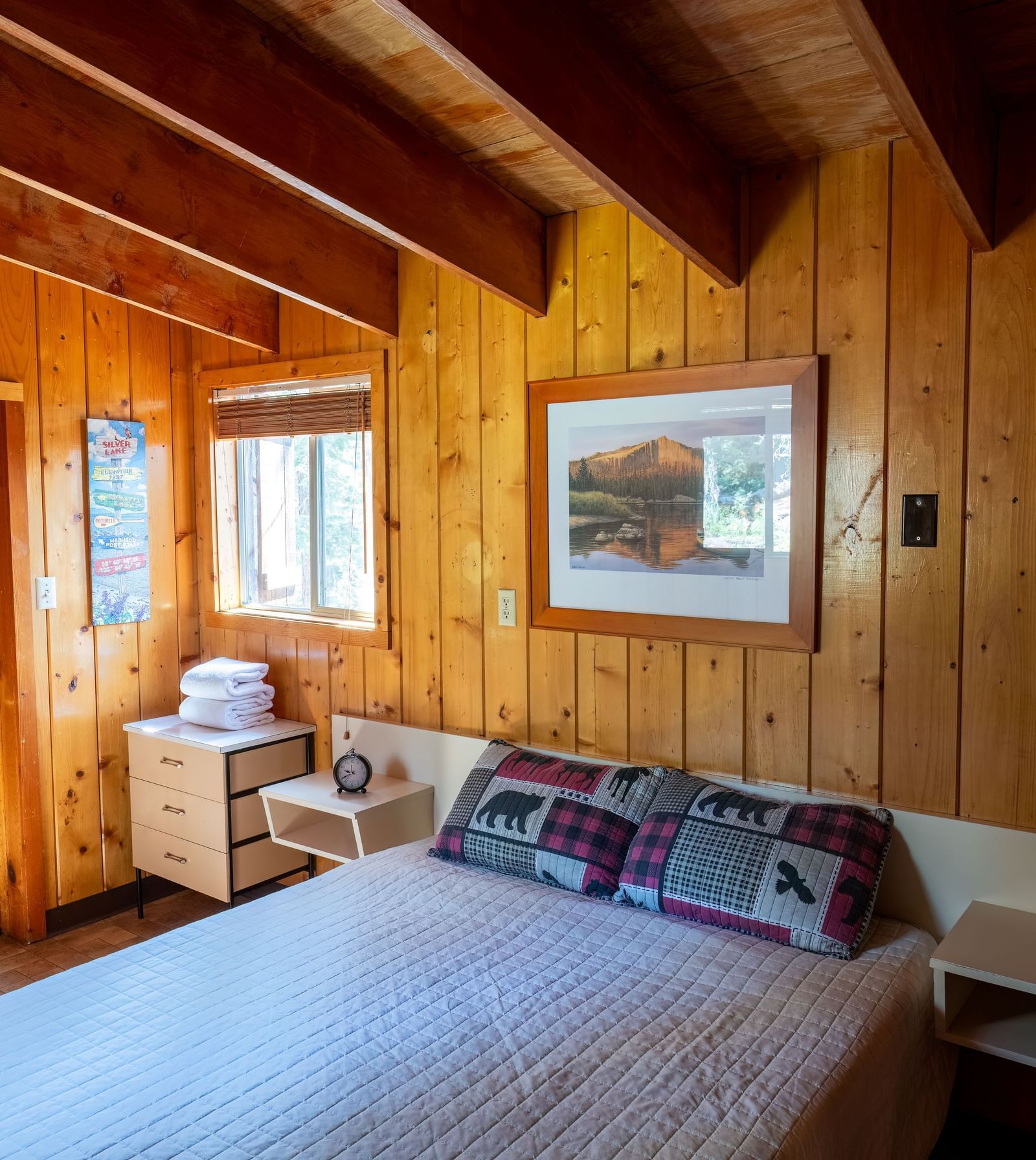 Cozy bedroom with large windows and cabin-style bedding at Kit Carson Lodge.