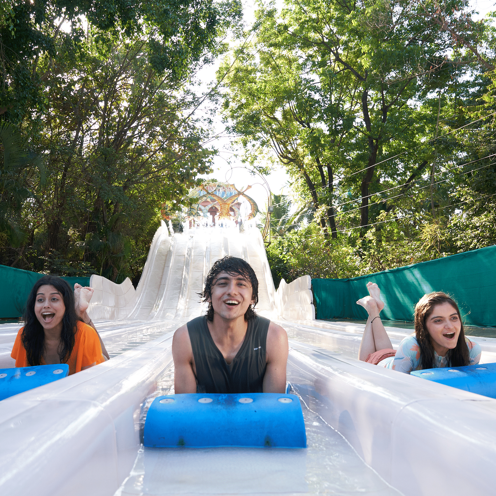 Three people enjoying What-A-Coaster at Water Kingdom while sliding down