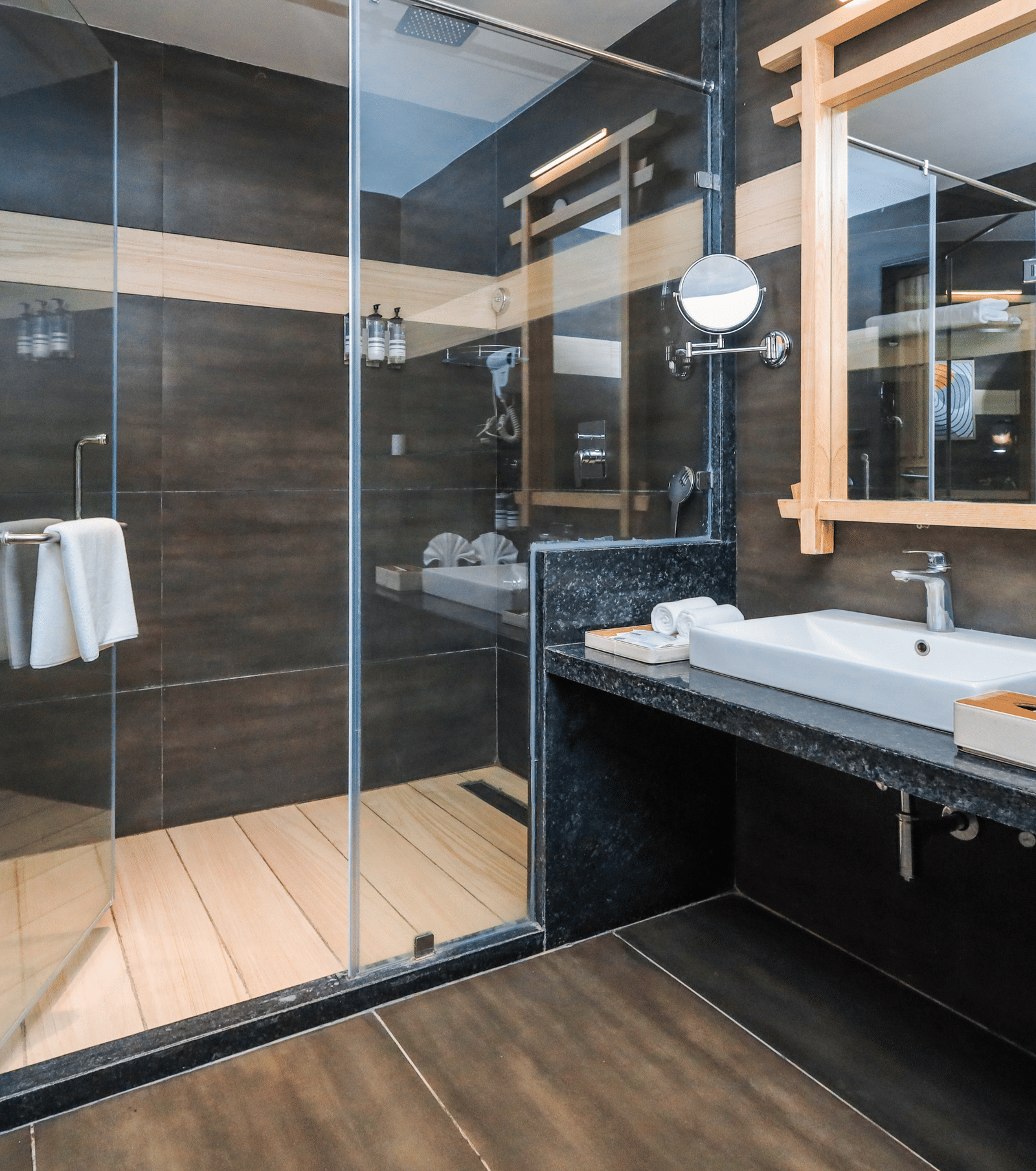 A bathroom with a vanity counter, sink, mirror and shower enclosure at Ananta Spa & Resort, Jaipur.