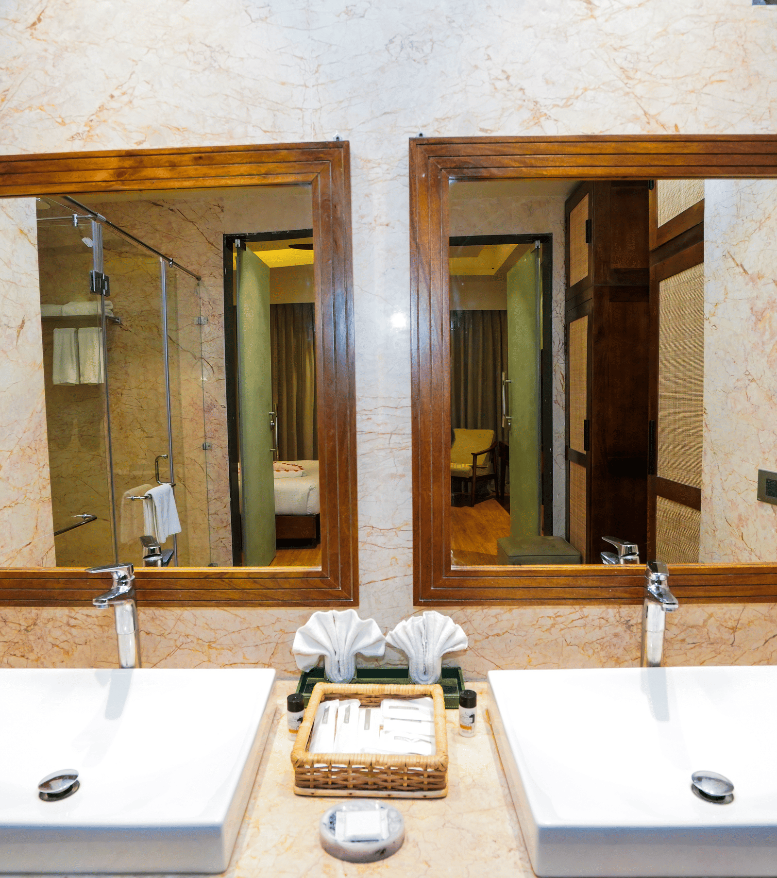 A close-up of the double vanity area with square white sinks and matching mirrors at Pushkara Resort & Spa.
