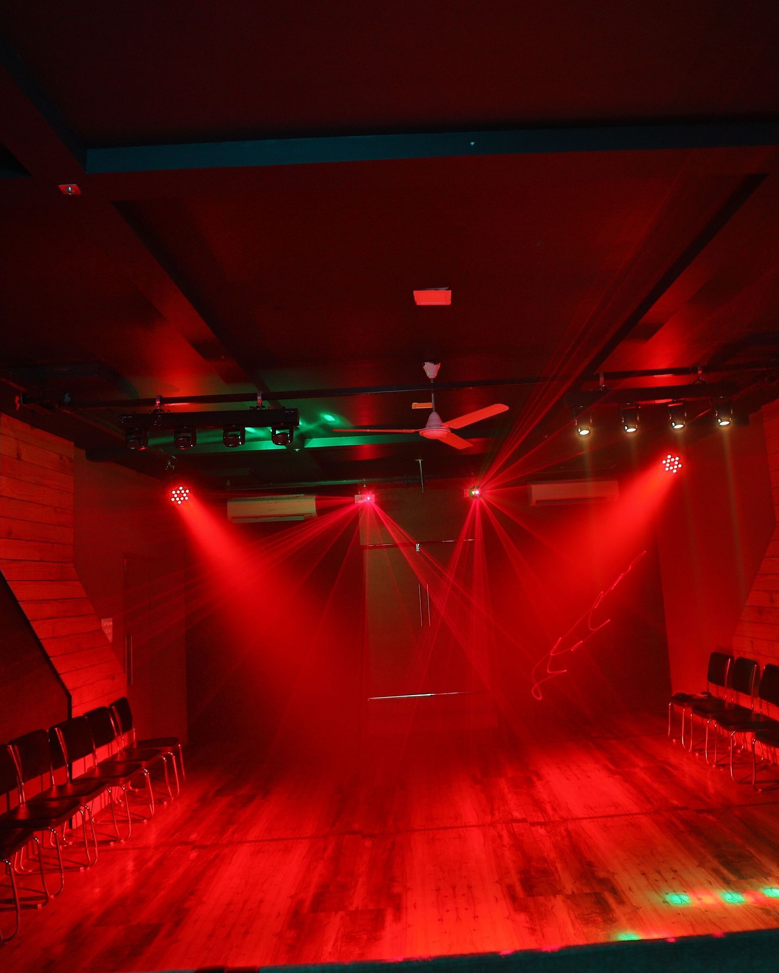 A dimly lit dance floor with flashing red lighting - Vishal Lords Inn Gir Forest