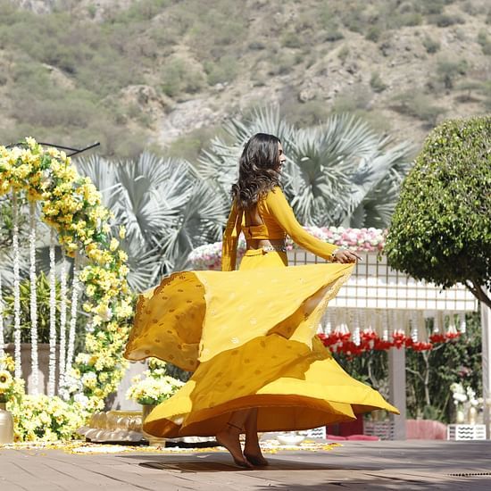 a girl in yellow dress swirling in a wedding venue