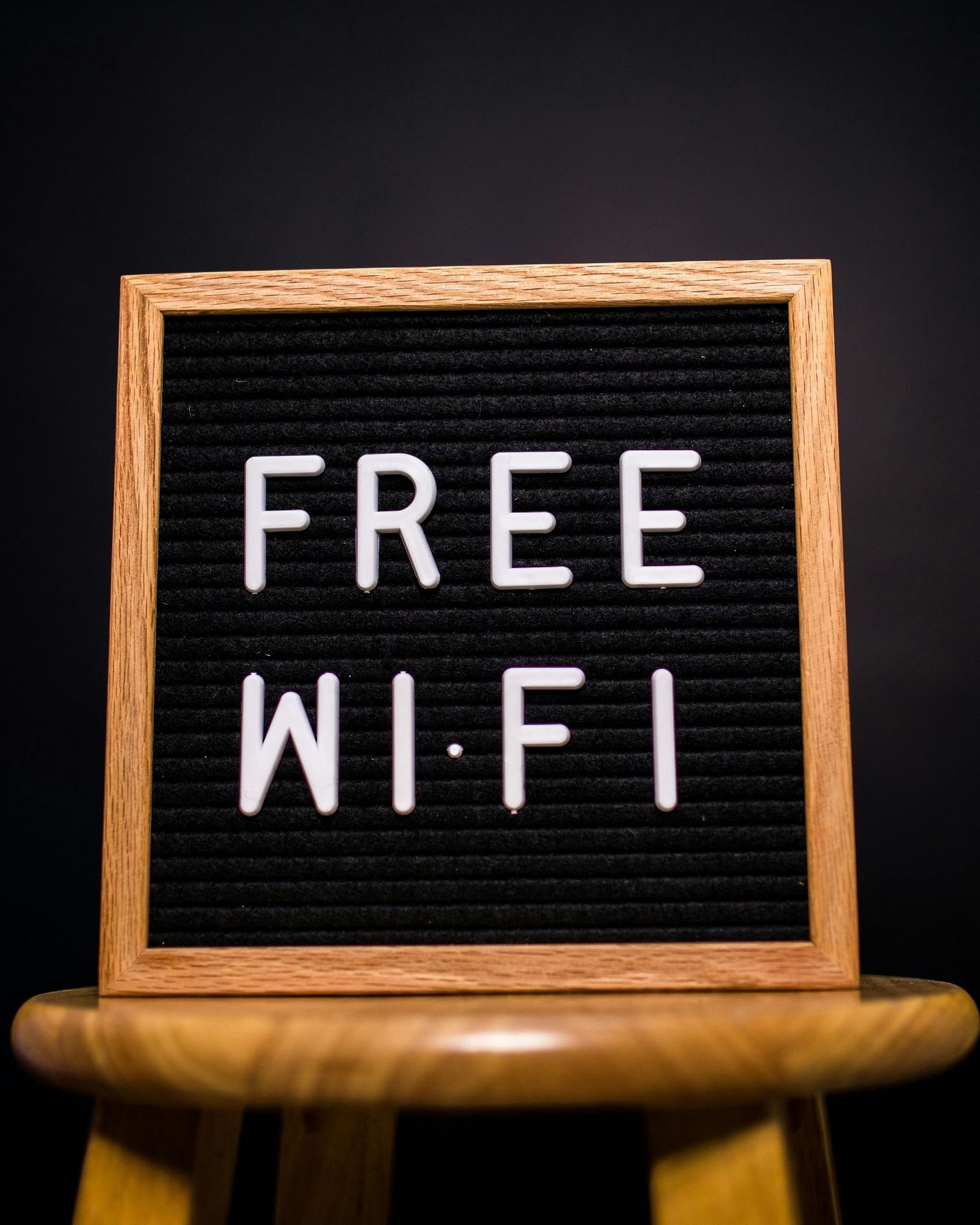 A black letter board resting on a small wooden easel displays the white text 'FREE WI-FI'.