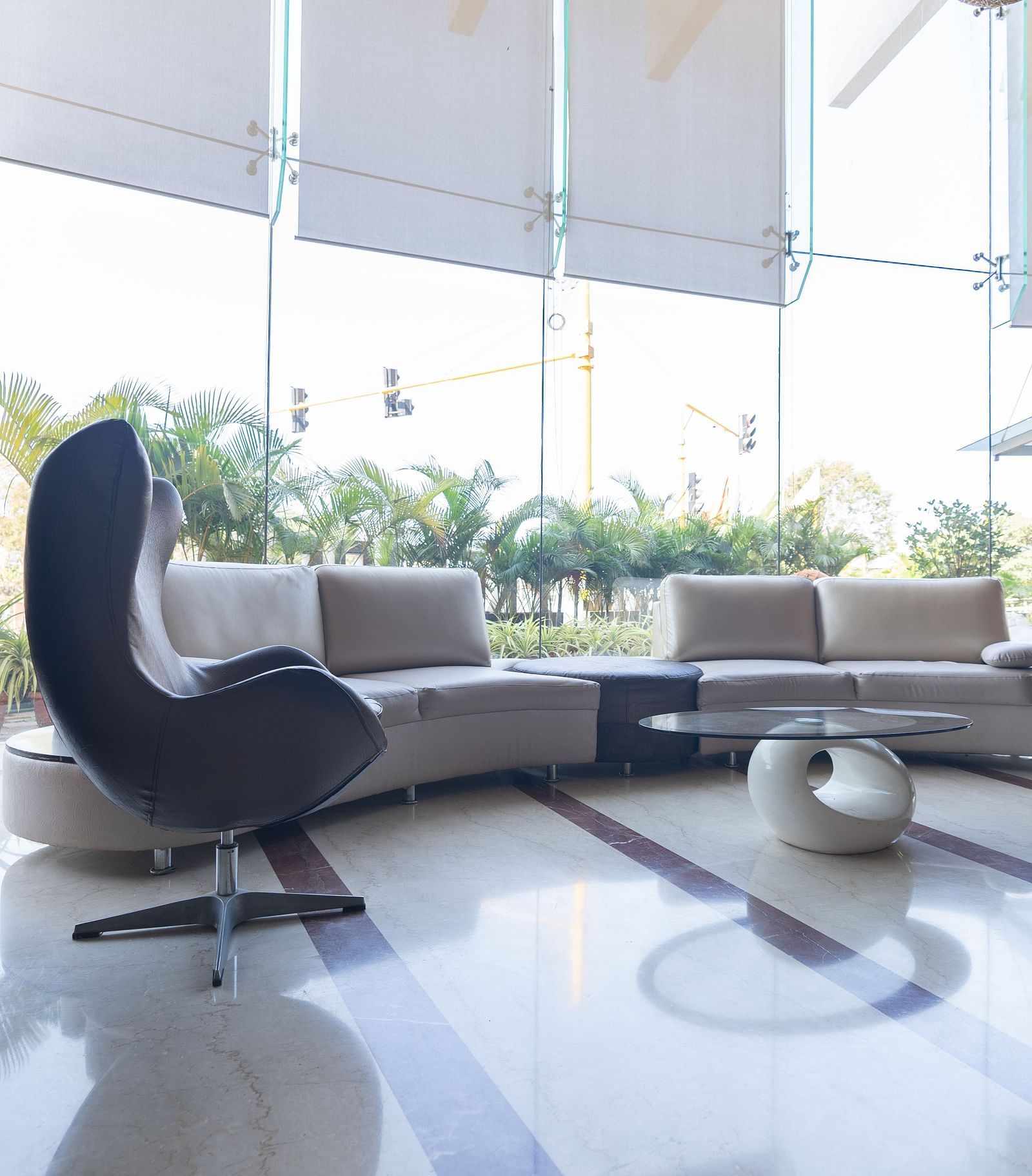 waiting area with a lounge, chairs and a round table at The President Hotel, Hubli