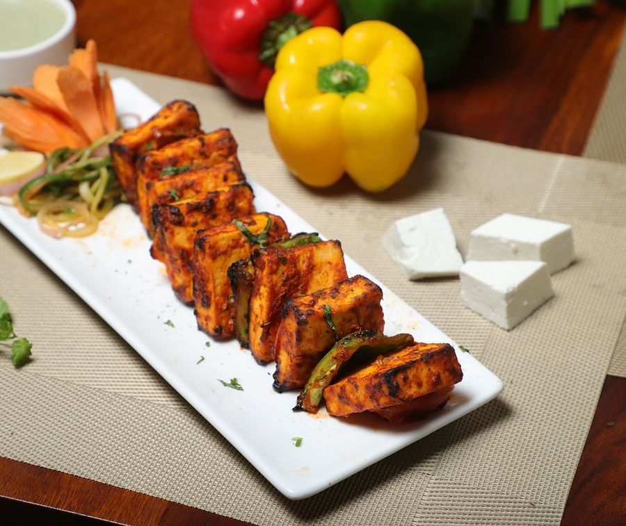 An image of paneer served with sauces  in a platter, and there are also capsicums and peas on the side at Five Elements Hotel, Jodhpur 