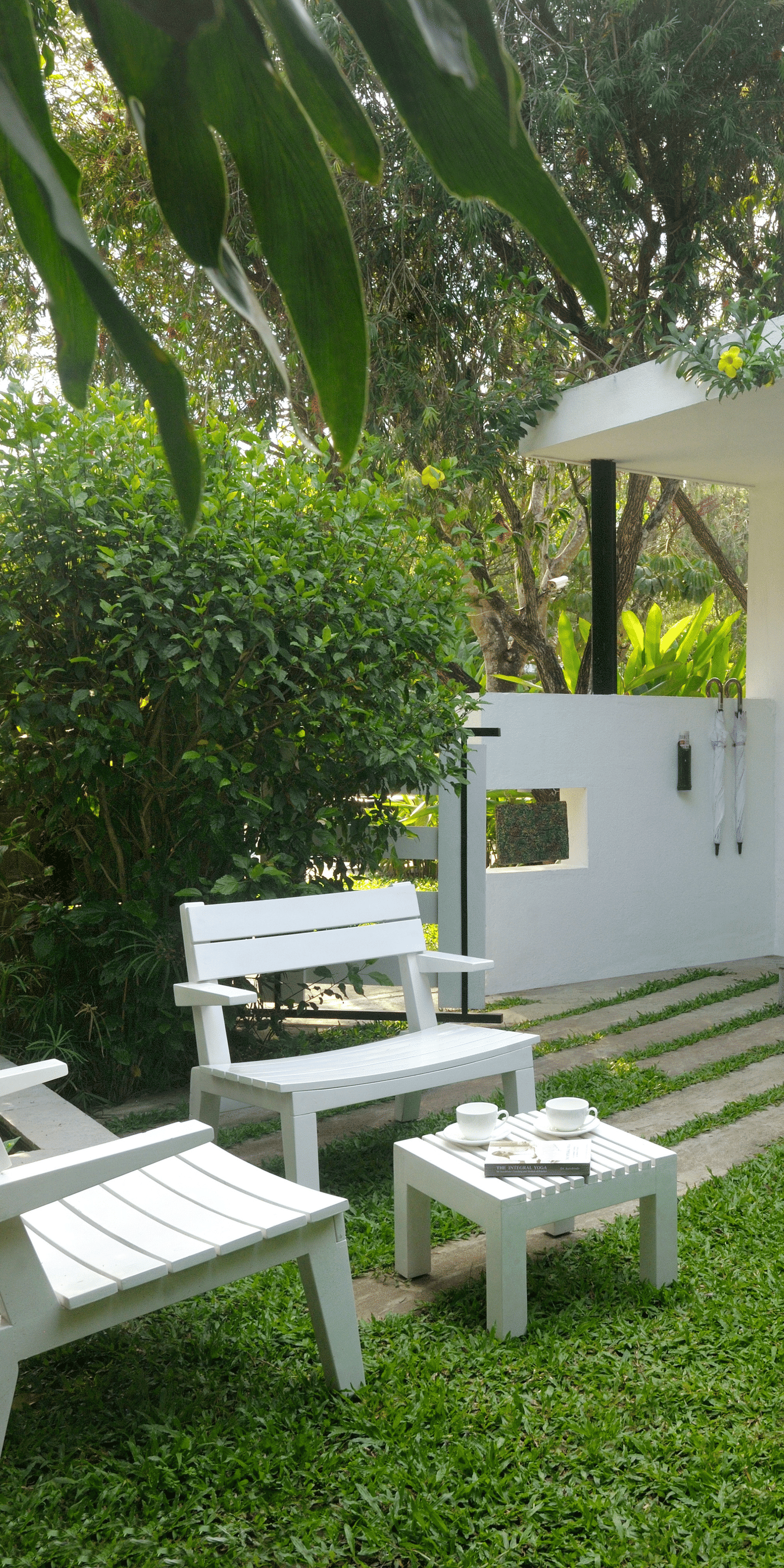 White outdoor seating arrangement at the garden-courtyard at Amanvana Spa Resort, Coorg