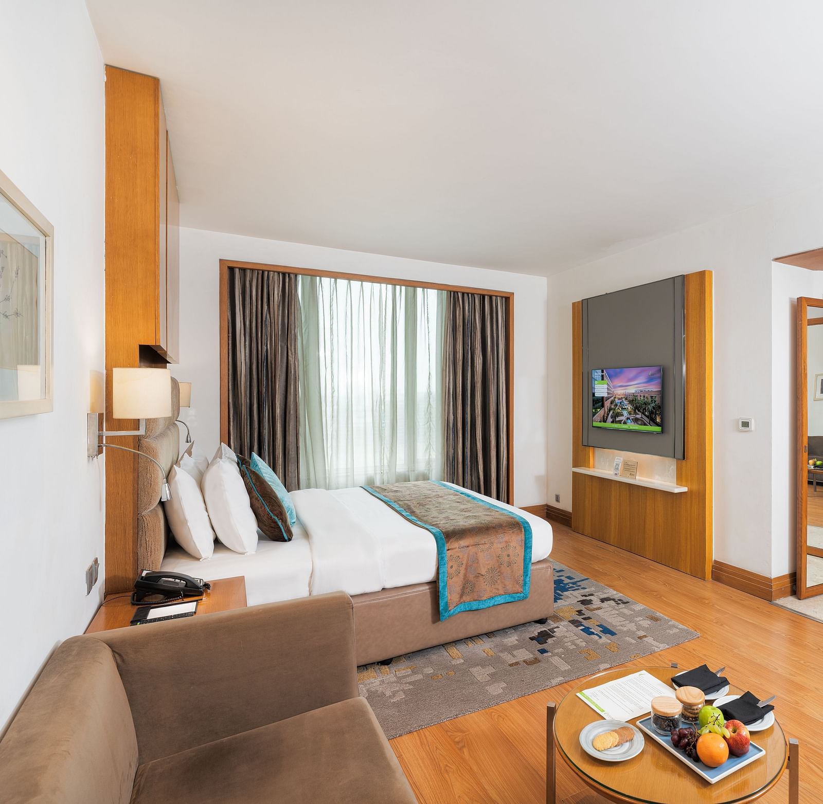 Elegantly furnished executive room featuring a comfortable seating area, work desk, and ample natural light - Nirvana Luxury Hotel, Ludhiana