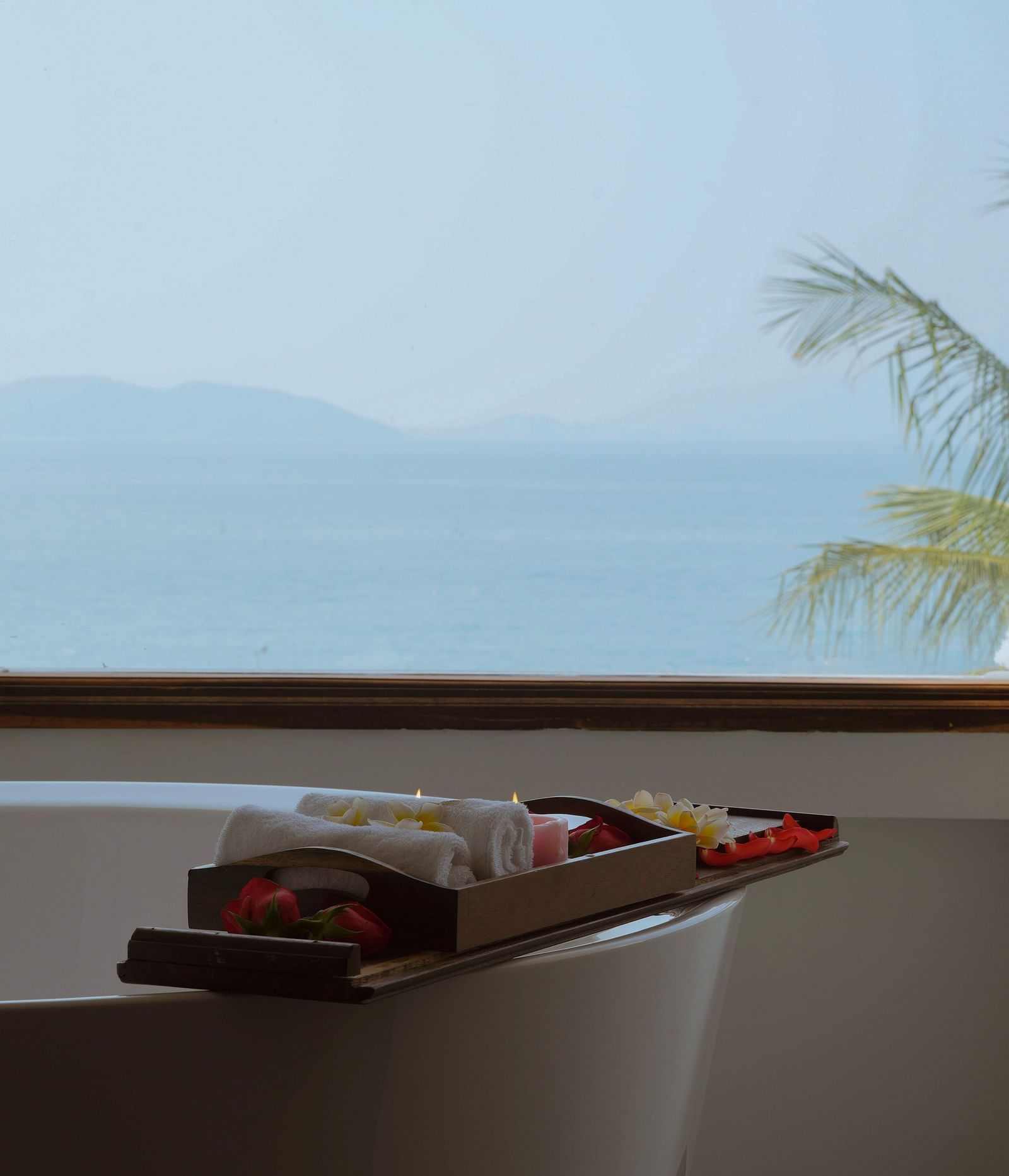 A image of a bathtub near a window overlooking the beautiful landscape - Alibu Resort