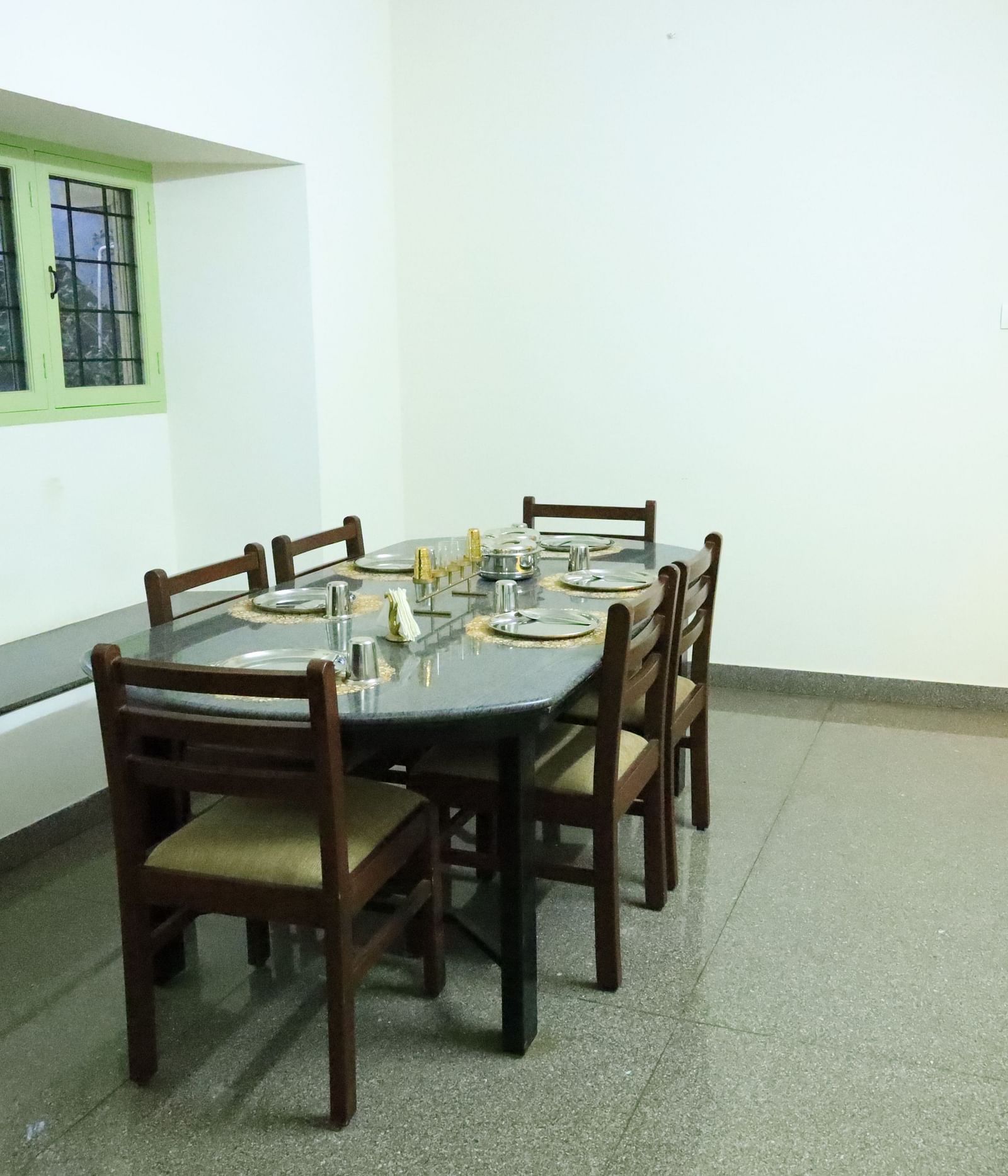 Image of a bright and airy dining room with large windows.