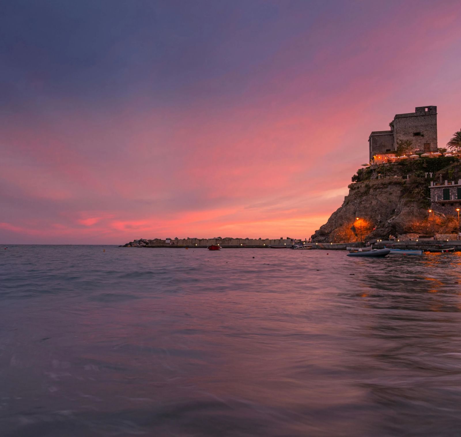 A panoramic view of a fort situated on a cliff side featuring a beautiful evening sky with blue and pink hues..
