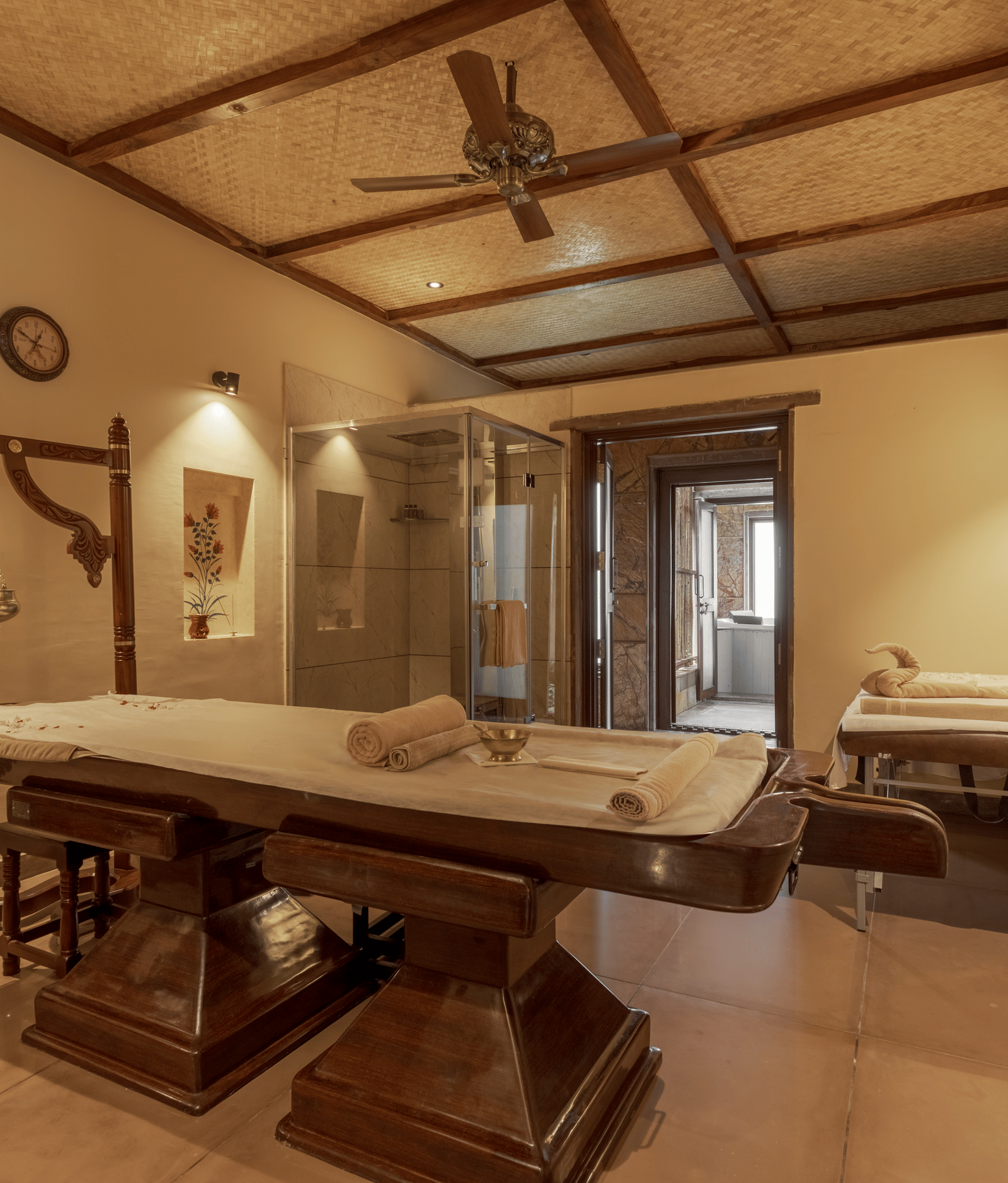 A serene spa treatment room with traditional wooden massage beds at Aamaghati Wildlife Resort.