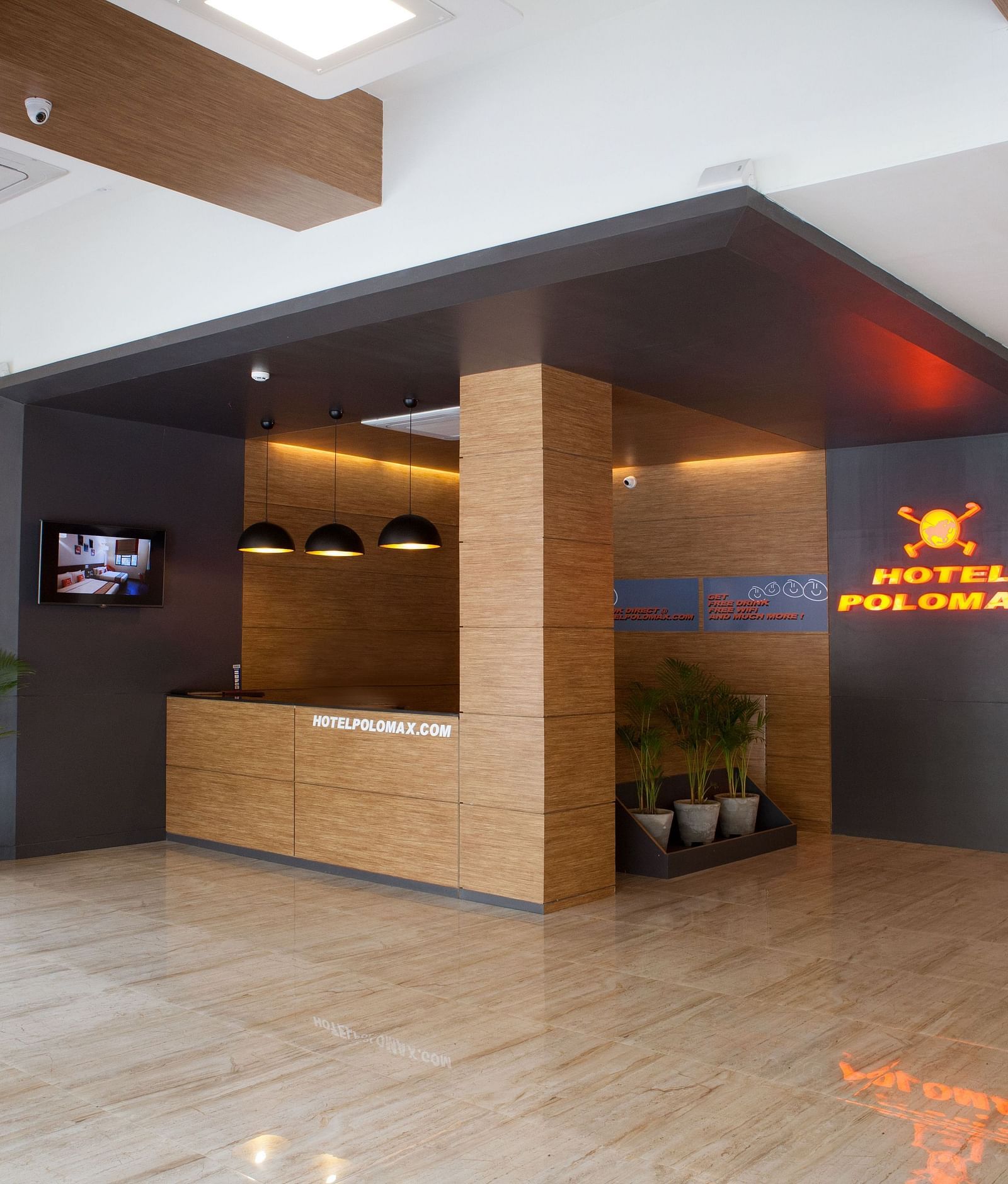 The lobby area of Max Hotel Jabalpur, featuring a reception desk, and the hotel's logo on the wall.