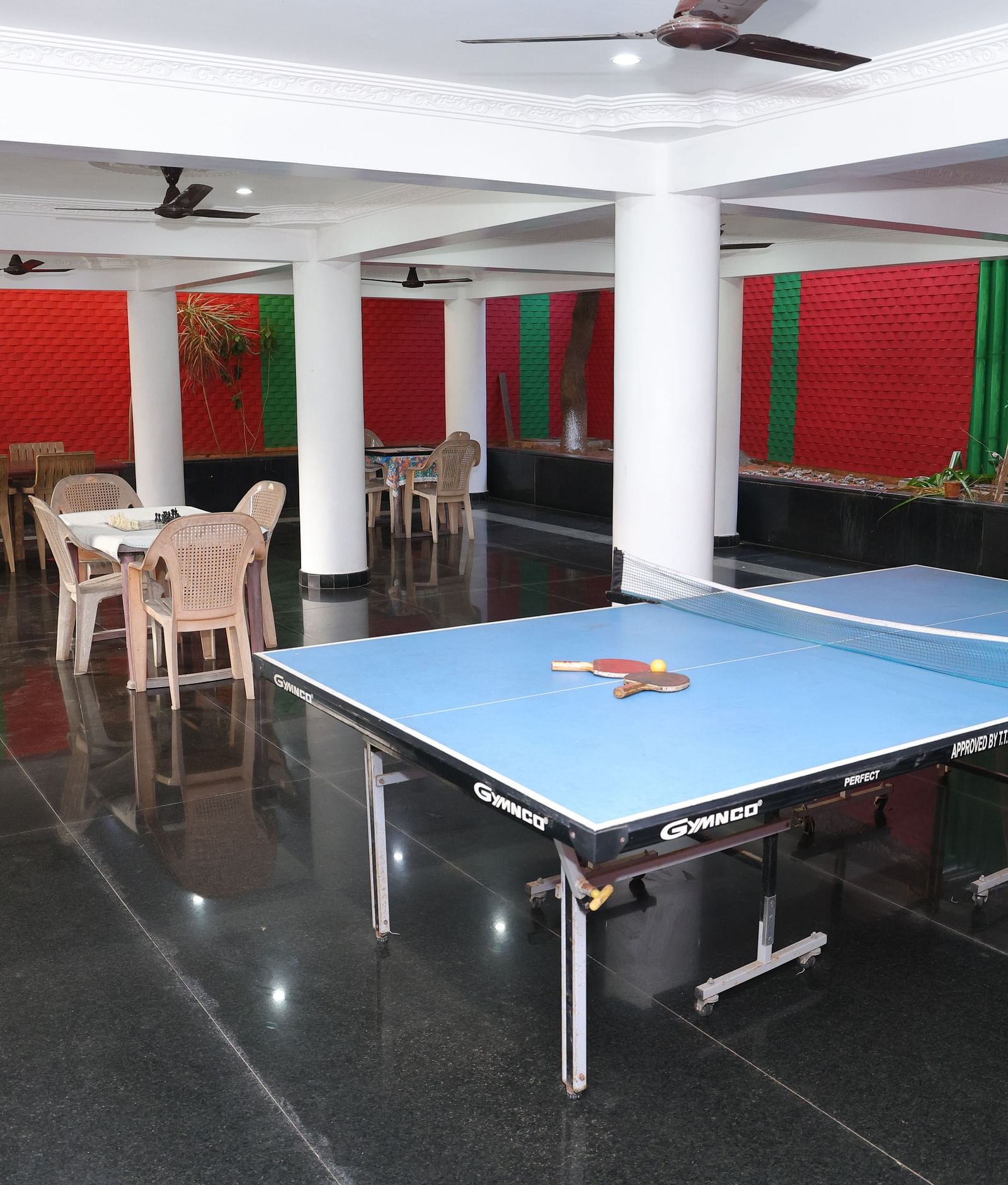 Image of a games zone with a table tennis board and chairs and tables in the background at Villa Serenity Le Sejour, Pondicherry.