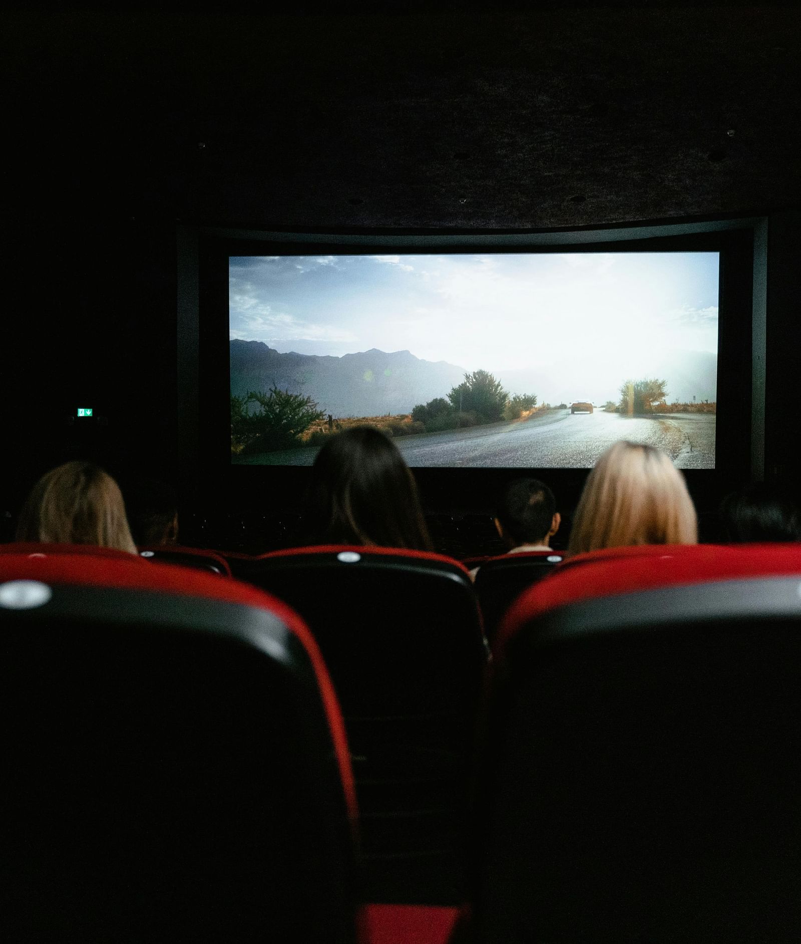 View from the back seat of the theatre, capturing people enjoying a movie