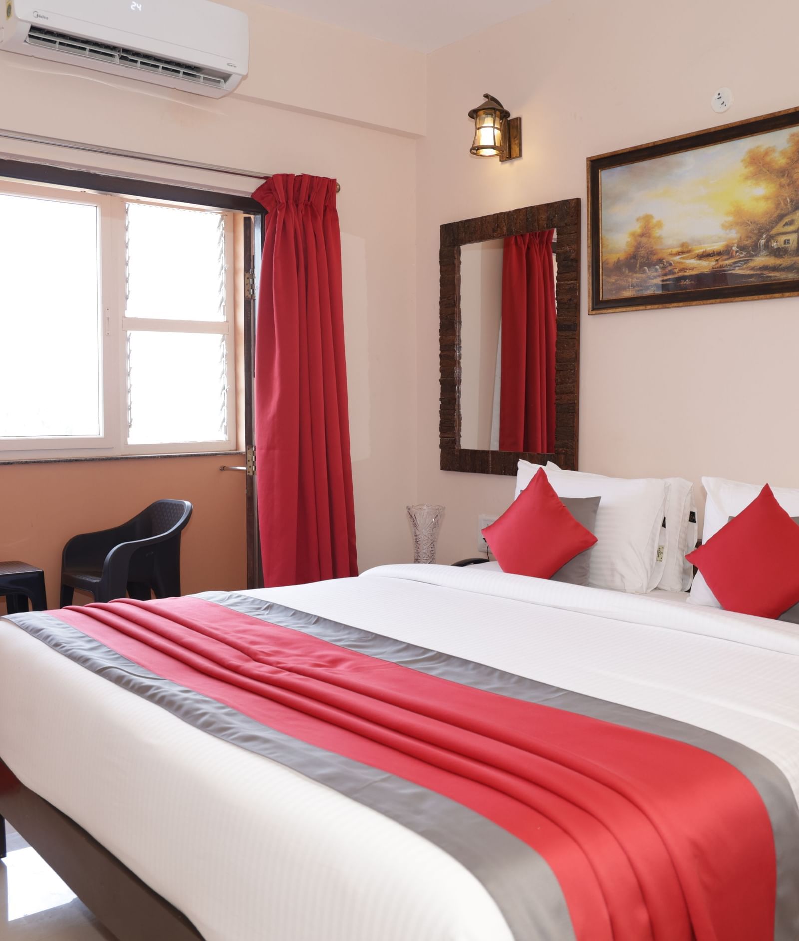 A bed placed near a window with curtains, wall art, bedside tables at Nazri The Verda Hotel, Arambol.