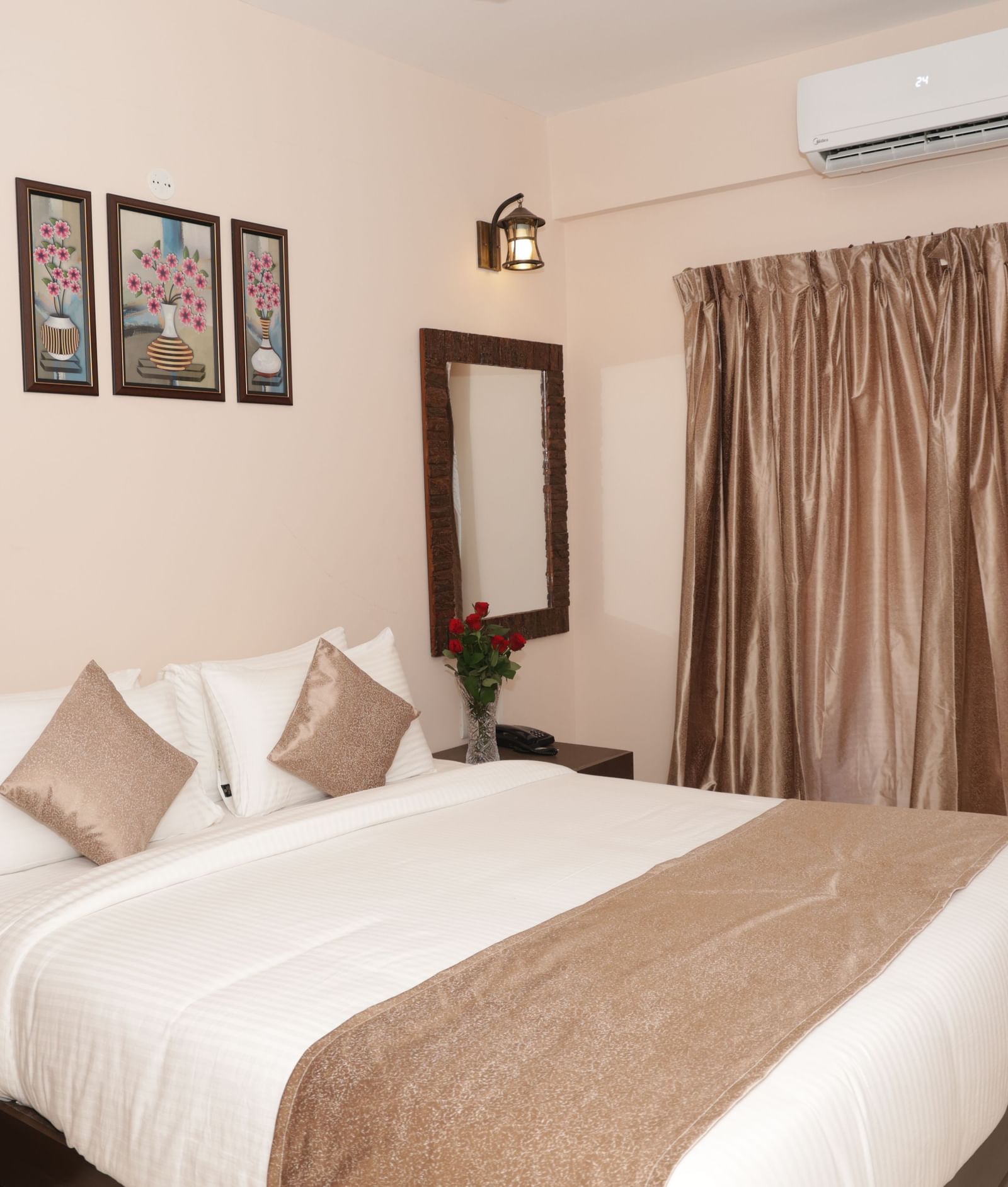 A bed with pillows, bedside tables, flowers and window curtains at Nazri The Verda Hotel, Arambol.