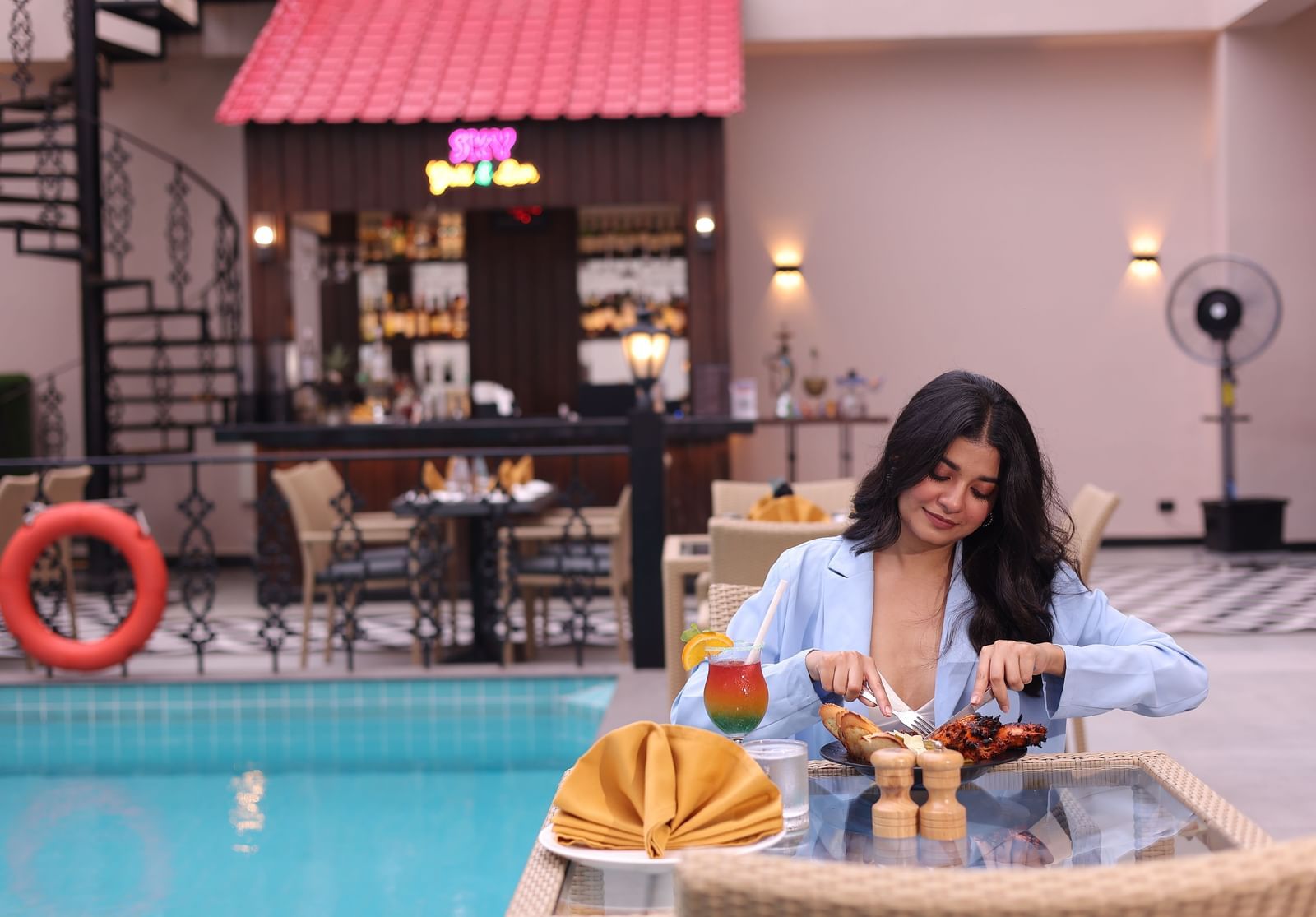 A woman having breakfast spread by the pool at our hotel in Agartala - Polo Hotel Agartala