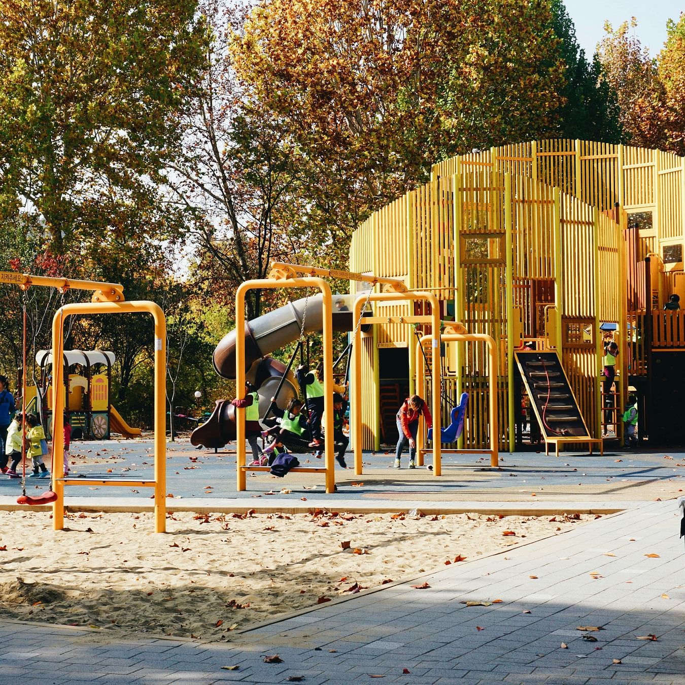 Kids playing  with all the play equipment during mid day 