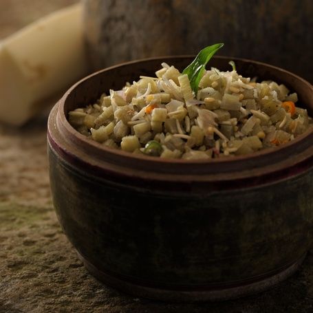Bowl of banana stem and lentil dish with vegetables.