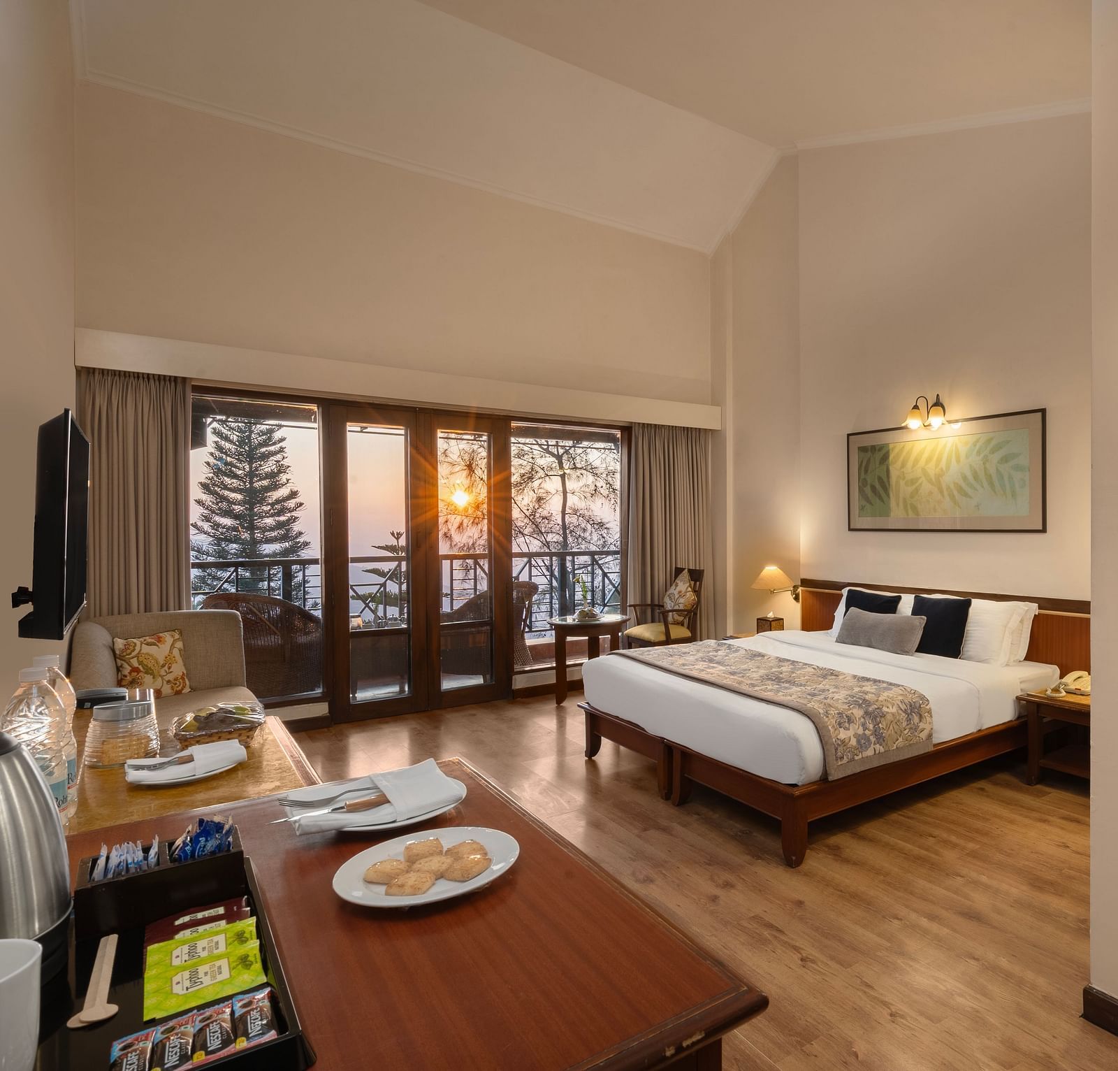 A corner view of Superior Room with plushy bed, table, wall mirror at Baikuth resort, kasauli.